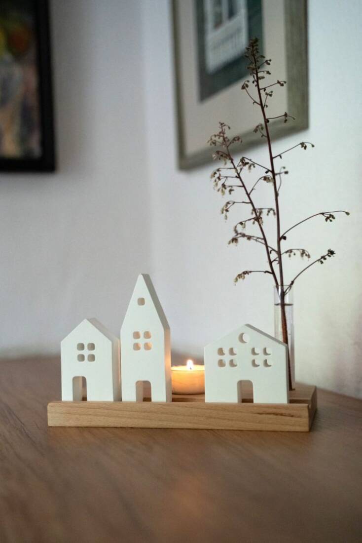 Miniatur-Häuser mit Teelicht und Glasvase