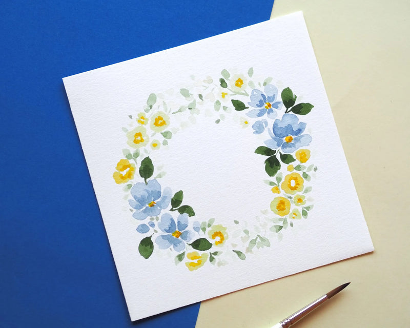 Nahaufnahme eines Aquarell-Gemäldes: Ein floraler Blütenkranz mit verschiedenen Blüten und Blättern in sanften Farben, Bild verlinkt zum Workshop.