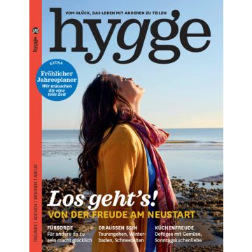Cover des Magazins "hygge". Eine Person steht am Strand, blickt gen Himmel. Text: "Los geht's! Von der Freude am Neustart". Themen: Fürsorge, Draußen sein, Küchenfreude. Zusätzlicher Fröhlicher Jahresplaner.