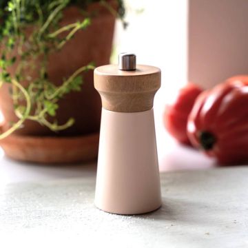 Zylindrische Pfeffermühle mit hellem, mattem Gehäuse und rundem Holzaufsatz mit Metallknopf, stehend auf heller Oberfläche; im Hintergrund Topf mit Grünpflanze und zwei rote Tomaten.









ChatGPT fragen
