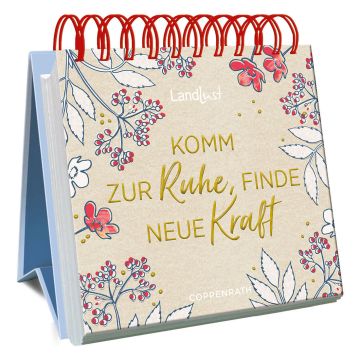 Aufstellkalender mit roter Spiralbindung, blumigem Design und der Aufschrift „Komm zur Ruhe, finde neue Kraft“. Markenname „Landlust“ oben, „Coppenrath“ unten. Hintergrund in natürlichem Beige gehalten.