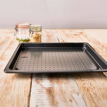 Schwarzes, perforiertes Backblech mit verstellbarer Breite. Das Blech hat kleine Löcher zur besseren Luftzirkulation beim Backen und steht auf einer neutralen Oberfläche.