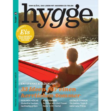 Titelblatt der Zeitschrift „hygge“ mit einer Person in roter Hängematte über einem See; Titel: „33 Ideen für einen herrlichen Sommer“; Themen: Eisrezepte, glutenfreies Backen, Stadtoasen, naturnahes Campen; sommerliche Naturkulisse im Hintergrund.