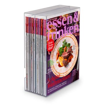 Ein transparentes Zeitschriftenregal mit mehreren Ausgaben der Zeitschrift "essen & trinken", die vorne sichtbar ist. Das Cover zeigt ein Festtagsgericht auf einem Teller und trägt den Titel "Schöne Weihnachten!".