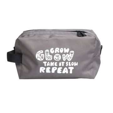 Graue Kosmetiktasche mit schwarzem Reißverschluss. Aufdruck vorne: "GROW GLOW TAKE IT SLOW REPEAT" in Weiß mit floralem Design.