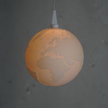 Leuchtkugel mit Konturen der Kontinente, aufgehängt an einem Kabel. Die Oberfläche ist dezent strukturiert, und die Kugel strahlt ein weiches, warmes Licht aus. Hintergrund in dunklen Grautönen.