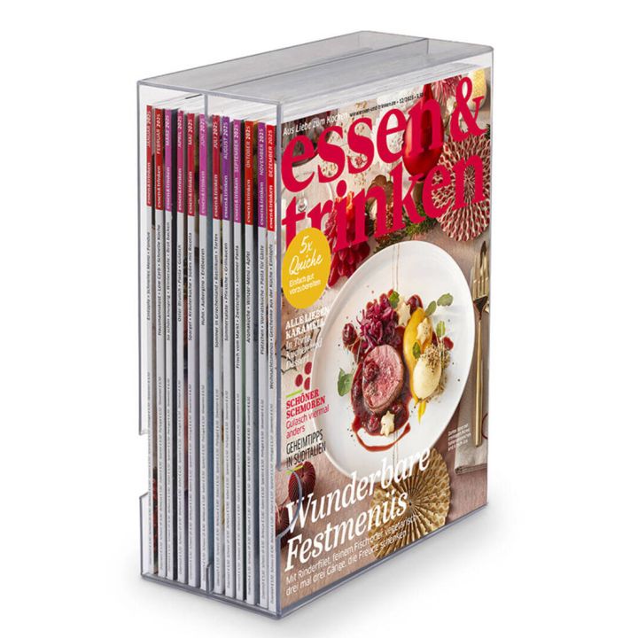 Ein transparentes Zeitschriftenregal mit mehreren Ausgaben der Zeitschrift "essen & trinken", die vorne sichtbar ist.