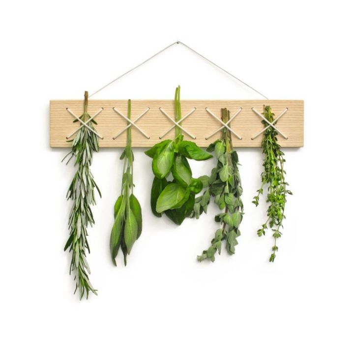 Holztäfelchen mit Haken, an denen fünf Bündel frische Kräuter hängen: Rosmarin, Salbei, Basilikum, Oregano und Thymian. Die Anordnung ist dekorativ und dient zur Aufbewahrung von Kräutern in der Küche.