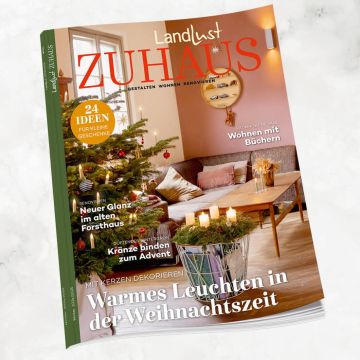 Zeitschrift "Landlust Zuhause" mit Wohnzimmermotiv: geschmückter Weihnachtsbaum, Adventskranz mit Kerzen, Sofa mit Kissen, Geschenktipps, Renovierungsideen „Neuer Glanz im alten Forsthaus“, Schwerpunkt auf Kerzendekoration und Büchern in Raumgestaltung.