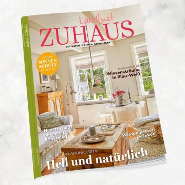 Magazin „Landlust ZUHAUS“. Cover mit Themen: Sonnenschutz im Garten, Neustart auf einem Bauernhof, Wiesensträuße in Blau-Weiß, Wimpelketten stricken. Schwerpunkt: Heller und natürlicher Landhausstil. Zeigt helles Wohnzimmer mit Holzmöbeln und Pflanzen.