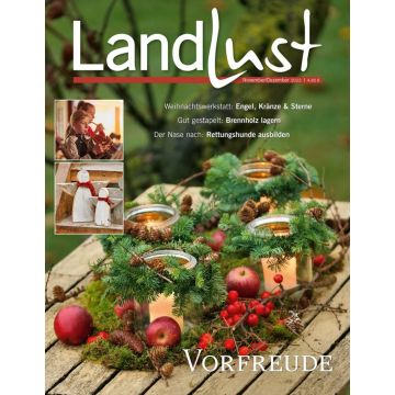 Titelbild der Zeitschrift „Landlust“ November/Dezember 2022. Hauptmotiv: Dekorierte Tannenzweiggestecke mit Kerzen, Äpfeln, und Beeren auf Holztisch. Oben links: Kinder beim Musizieren, handgemachte Holzwichtel.