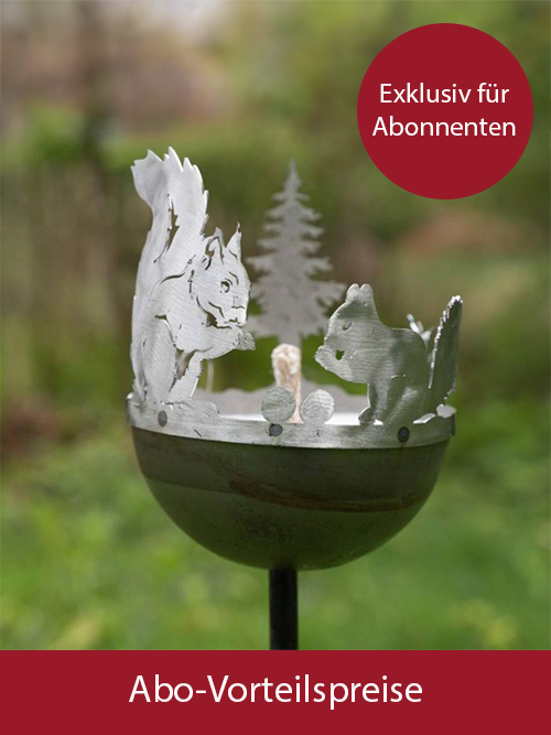Eine Gartenfackel aus Metall ist mit einer Grafik von Eichh&ouml;rnchen verziert. Sie steht vor einem gr&uuml;nen Garten-Hintergrund.