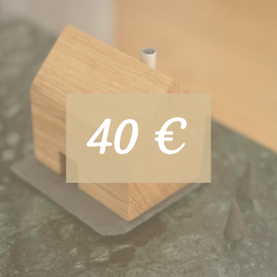 Ein kleines Holzhaus steht auf einem dunklen Fläche. Text: 40 Euro