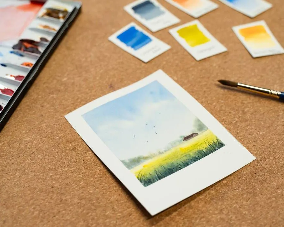 Detailaufnahme eines Blattes. Ein einzelnes, detailliert gemaltes Blatt auf Aquarellpapier, daneben ein Pinsel, Bild verlinkt zum Workshop.