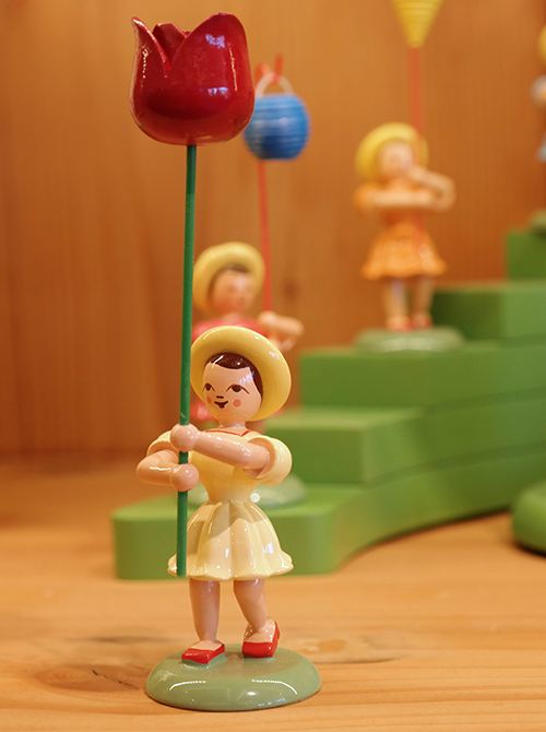 Eine Holzfigur mit Blume in der Hand