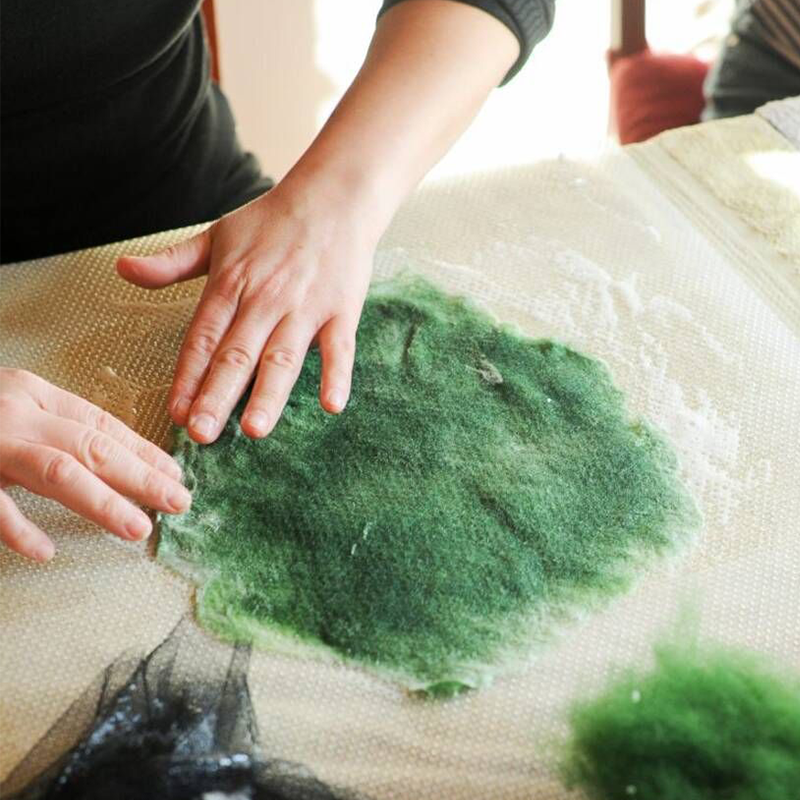 Ein Tannenbäumchen wird gefilzt. Zuerst wird die Wolle ausgebreitet