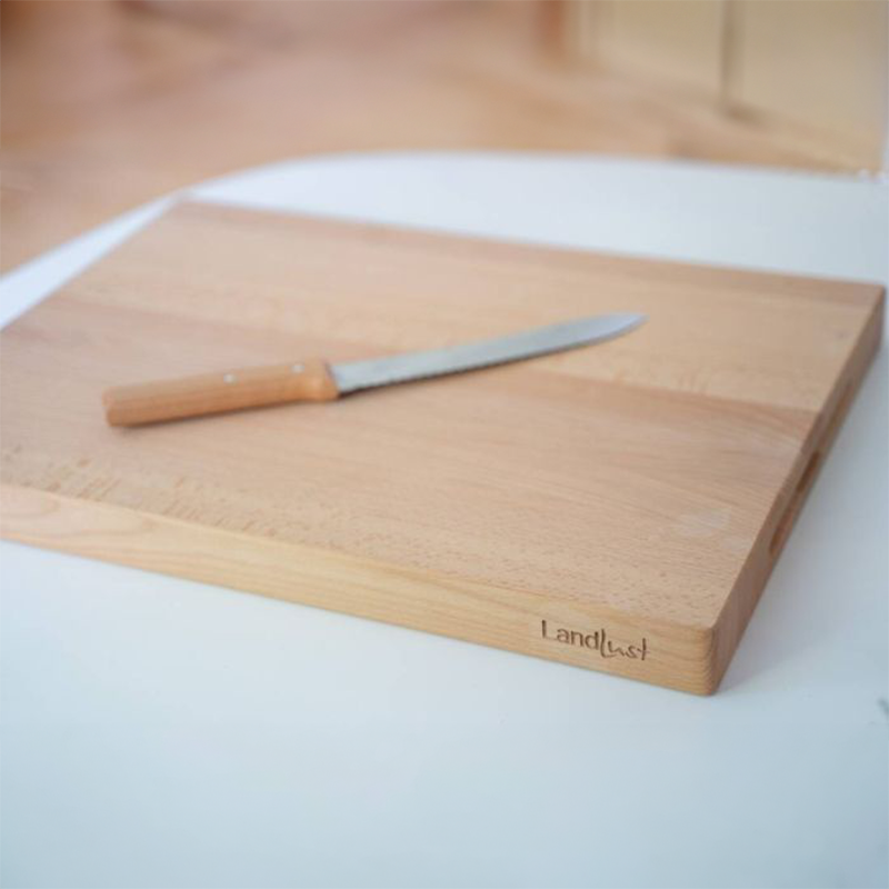 Ein Holzbrett liegt auf einer weißen Fläche
