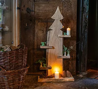 Eine aus Holz hergestellte Tanne mit Ablagen auf denen Kerzen und Tannenzweige dekoriert sind.