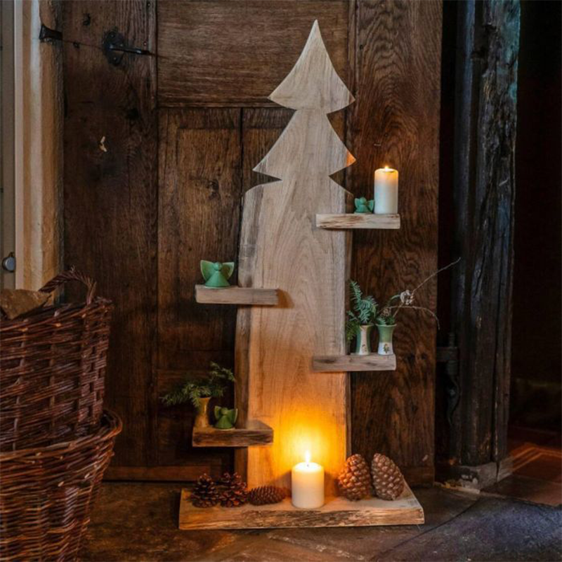 Eine aus Holz hergestellte Tanne mit Ablagen auf denen Kerzen und Tannenzweige dekoriert sind.