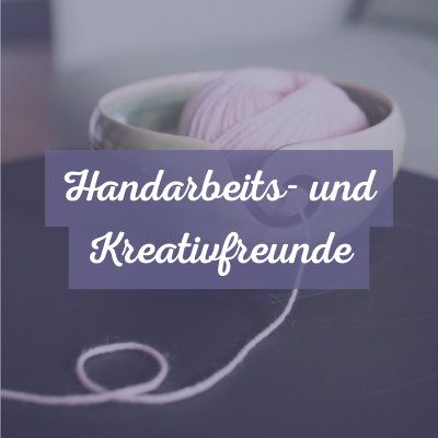 Eine gr&uuml;ne Garnschale aus Keramik mit lila-farbener Wolle steht auf einem kleinen Tisch. Text: Handarbeitsfreunde