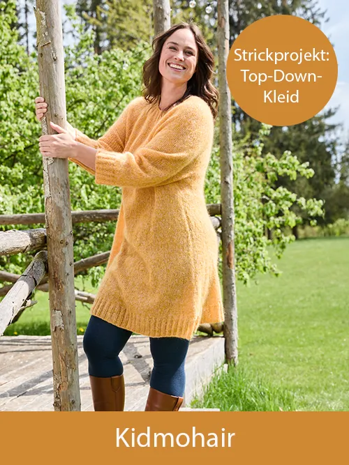 Eine lächelnde Frau trägt ein selbstgestricktes, gelbes Kleid aus Landlust Kidmohair. Im Hintergrund sind Rasen und Bäume zu sehen. Oben rechts steht „Strickprojekt: Top-Down-Kleid". Bild verlinkt zur Kidmohair.