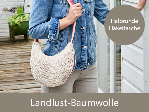 Eine lächelnde Frau trägt eine selbst gehäkelte halbrunde Häkeltasche. Sie steht neben einer Holzfassade. Text: Halbrunde Häkeltasche - Landlust-Baumwolle. Das Bild verlinkt auf die passende Wolle: Landlust-Baumwolle im Landlust Shop