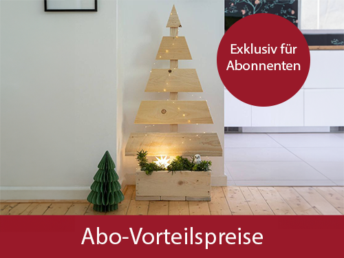 Ein vereinfachter Tannebaum aus Holz mit einem Dekokasten, gefüllt mit Tannenzweigen, steht in einer Wohnung. Ein roter Kreistext oben rechts zeigt „Exklusiv für Abonnenten“. Auf rotem Balken steht Abo-Vorteilspreise. Bild verlinkt zur Landingpage.
