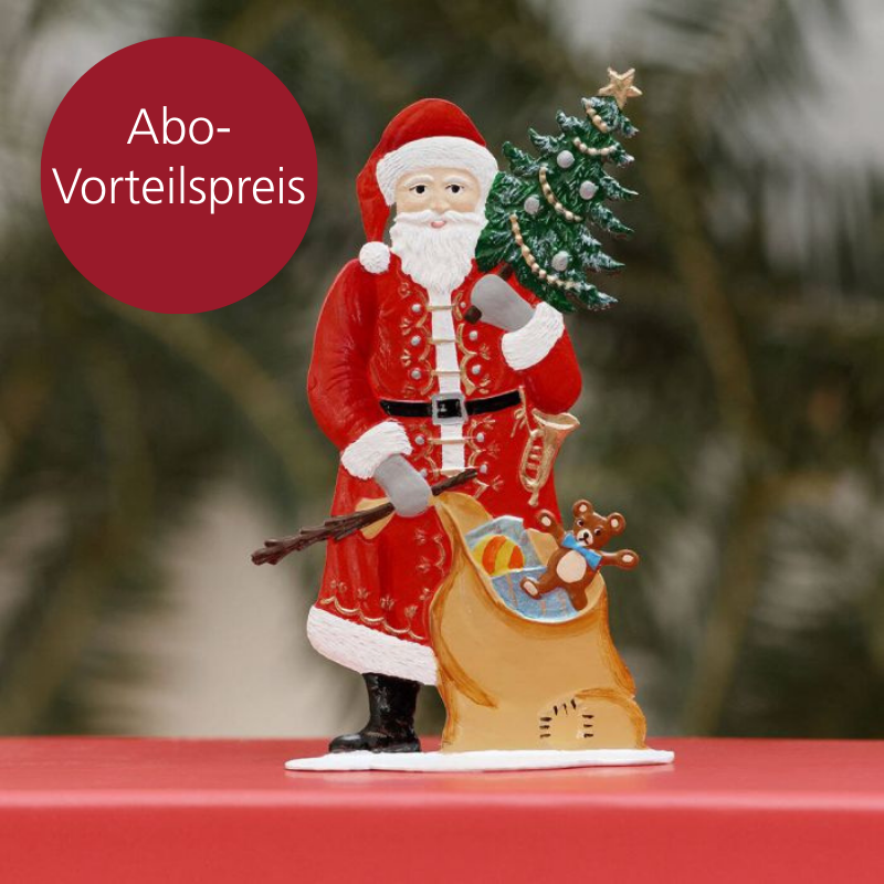 Eine Zinnfugr mit Weihnachtsmann-Motiv und Sack mit Geschenken steht auf einer roten Oberfläche