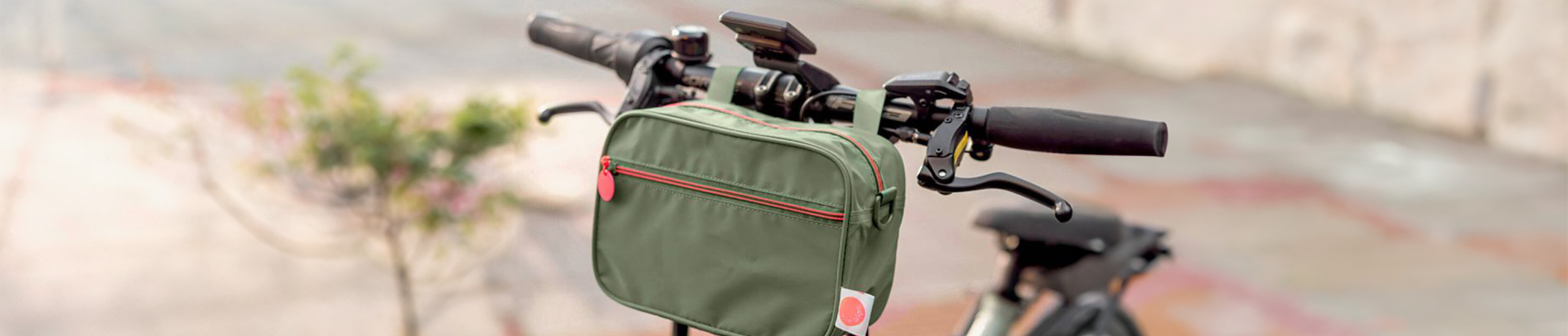 Eine extragroße Gebäckdose in Rot mit weihnachtlichen Motiven wird von einer Person mit grünem Oberteil gehalten